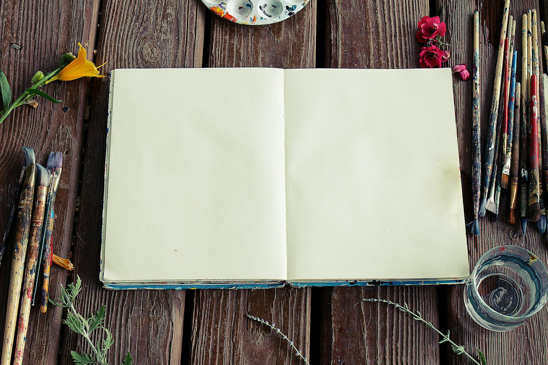 photograph of blank sketchbook and paint brushes